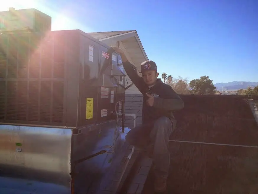 HVAC technician performing Heat Pump Repair on a rooftop unit in Minneola
